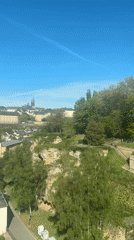 Clear morning skies over Luxembourg City with aircraft contrail