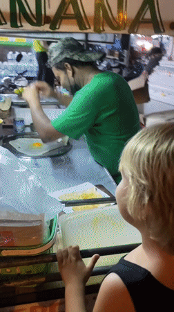 Street vendor serves food to customers in Thai village