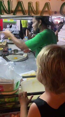 Street vendor serves food to customers in Thai village