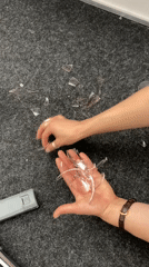 Person collects broken glass fragments from carpet in Moscow