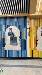 Pedestrians pass traditional mural in Beijing subway station
