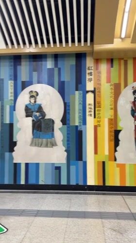 Pedestrians pass traditional mural in Beijing subway station