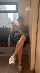 Young man waves from train window in London