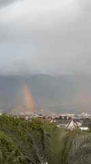 Rainbow spans sky above Fethiye, Turkey during cloudy weather