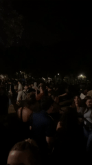 Large crowd gathers for nighttime outdoor social event