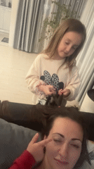 Girl plays with woman's hair in casual moment