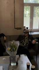 Man in brown blazer sits on green sofa in Moscow interior