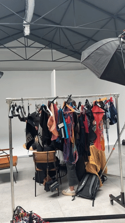 Milan studio glimpse shows clothing rack, person partially visible