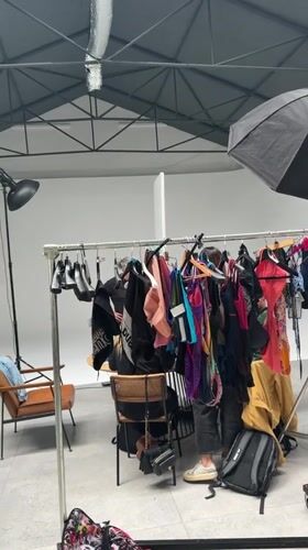 Milan studio glimpse shows clothing rack, person partially visible