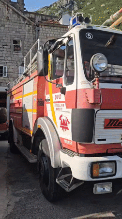 Fire trucks stationed in Perast, Montenegro during quiet afternoon