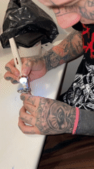 Tattooed person polishes silver ring in Buenos Aires workspace