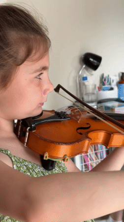 Young girl practices violin, writes in notebook in Strasbourg