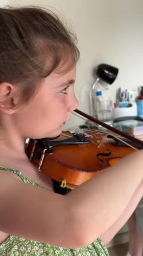 Young girl practices violin, writes in notebook in Strasbourg