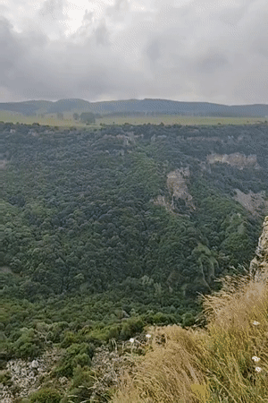 Dashbashi Canyon's steep green walls under a cloudy sky