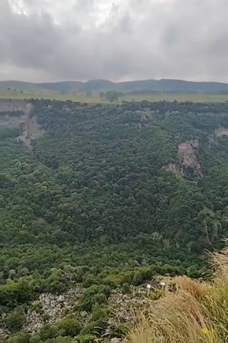Dashbashi Canyon's steep green walls under a cloudy sky