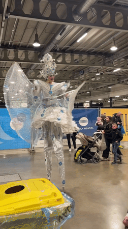 Costumed stilt walker performs in indoor Luxembourg venue