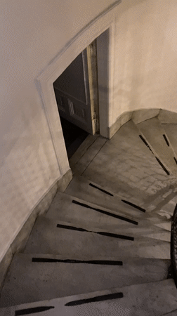 Person descends marble stairs in Buenos Aires building