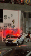 Police car lights flash during nighttime street stop in São Paulo