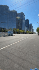 Morning cyclist rides past modern buildings in Beijing district