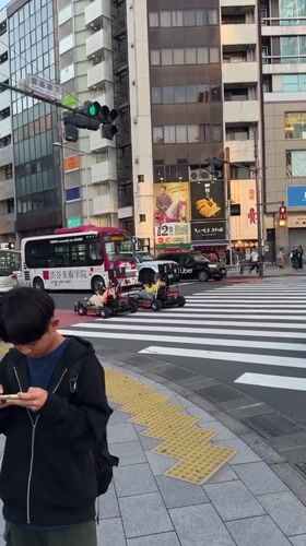 Go-karts navigate busy Shibuya crosswalk amid morning pedestrian traffic