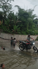 Children play in river as motorcycle passes, Saweuk Indonesia