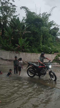Children play in river as motorcycle passes, Saweuk Indonesia