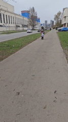 Woman helps young girl ride electric scooter in Moscow