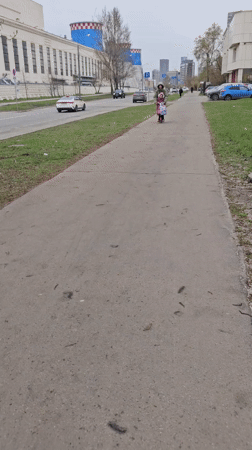 Woman helps young girl ride electric scooter in Moscow