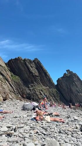 Crowded pebble beach on a clear sunny day