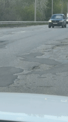 Cracked, potholed road documented in Kamyshin, Russia