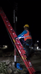 Night crew doing utility pole work roadside in Indonesia