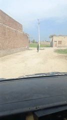 Person walks on rural dirt road in Pakistan