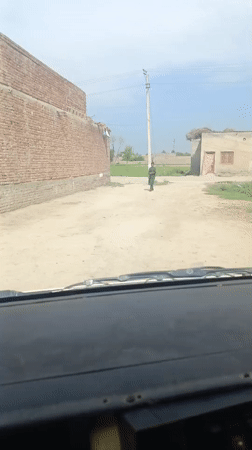 Person walks on rural dirt road in Pakistan