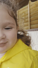 Child in yellow raincoat plays in London backyard