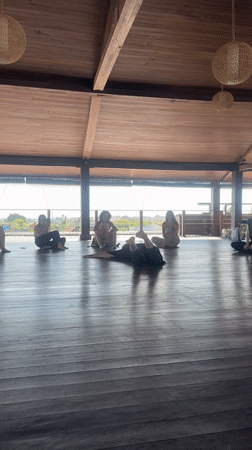 Dance instructor demonstrates moves to seated group in Mengwi