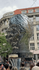 Prague's iconic reflective metallic head sculpture in a city square