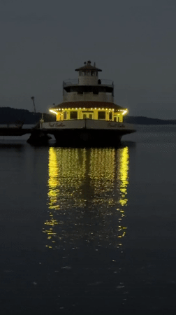 Point Ruston ferry glows at dusk, docked on calm water