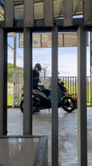 Motorcyclist checks phone while parked in Lhokseumawe