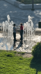 Children play in fountain amid spring blooms in Dmitrov