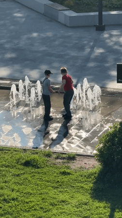 Children play in fountain amid spring blooms in Dmitrov
