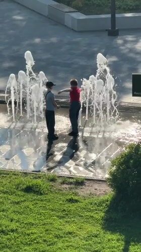 Children play in fountain amid spring blooms in Dmitrov