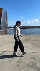 Woman jump ropes by Copenhagen canal as swan swims nearby