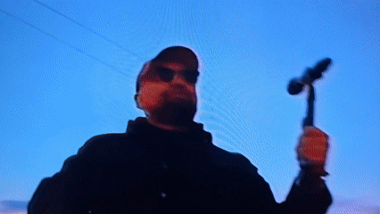 Nighttime musical performance draws crowd with raised hands