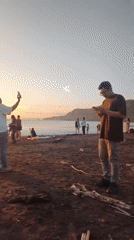 Sunset beach gathering draws photographers in Ciwaru, Indonesia