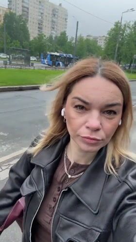 Woman films herself walking on wet street in Vsevolozhsk