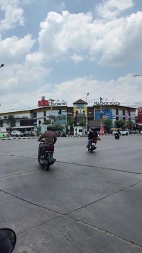 Morning traffic flows through Chiang Mai intersection with police presence