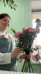 Woman photographs herself with flower bouquet in Izhevsk home