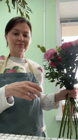 Woman photographs herself with flower bouquet in Izhevsk home