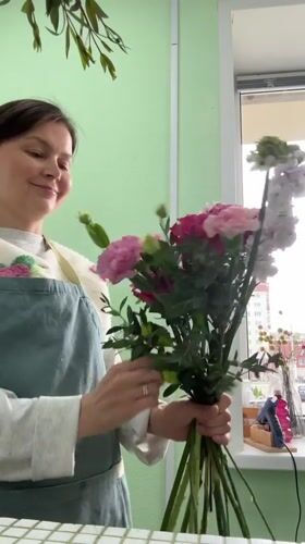 Woman photographs herself with flower bouquet in Izhevsk home