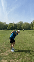Golfer practices swing on London field Sunday afternoon